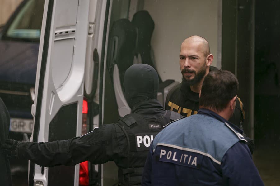 Policajti eskortujú influencera Andrewa Tatea na súd v Bukurešti 12. marca 2024. 