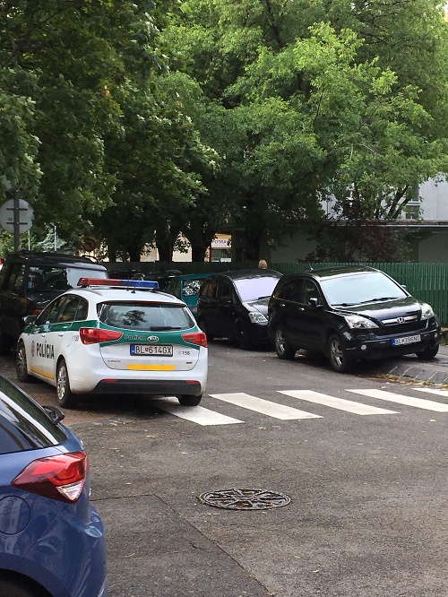 Policajné auto stojí na priechode pre chodcov.