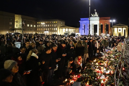 Pred Brandenburskou bránou v Berlíne sa zhromažďujú davy smútiacich ľudí.