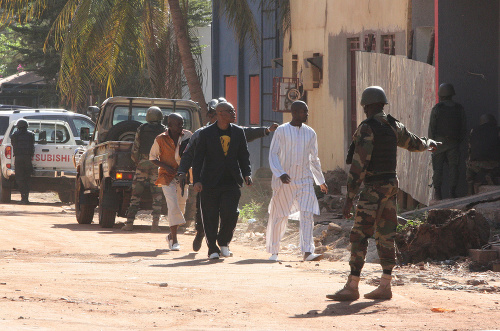Bezpečnostné jednotky eskortujú ľudí, ktorí utiekli z hotela Radisson Blu v malijskom meste Bamako.