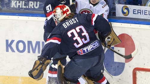 Brankár Barry Brust, vľavo v pozadí Tomáš Starosta (obaja Slovan) v súboji o puk pri mantineli s hráčom Kazane Andrejom Čibistovom.