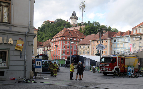 Hasiči a policajti stoja pri zničenom bicykli na mieste nehody, kde vodič terénneho vozidla vrazil do davu ľudí v centre Grazu na juhu Rakúska.