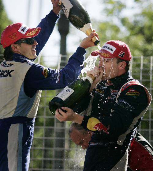 Holanďan Doornbos (vpravo) si užíva tradičnú sprchu perlivým mokom po úspechu v seriáli Champ Car.
