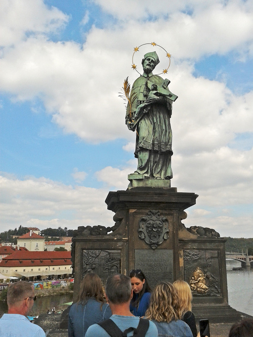 Ján Nepomucký: Medená socha svätca stojí podľa legendy na mieste, odkiaľ ho z mosta zhodili do Vltavy.