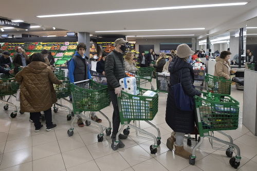 Zákazníci, niektorí s ochrannými rúškami, v supermarkete v španielskom Madride.