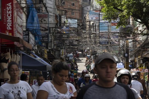 Chudobná štvrť Rocinha v brazílskom meste Rio de Janeiro, ľudia kráčajú bez rúšok.