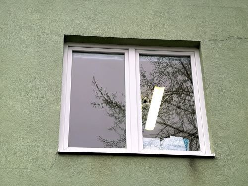 Okno po zasiahnutí guľkou zostalo poškodené.