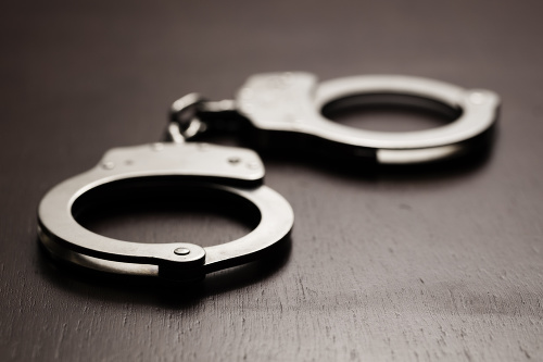 Pair of handcuffs sitting on a wooden desk