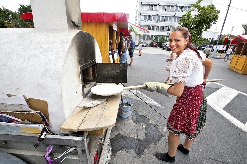 Lenka (22) dáva lepník do horúcej starej pece.
