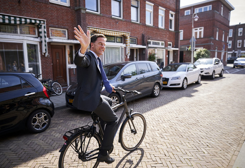 Holandský premiér Mark Rutte máva na bicykli po tom, čo odovzdal svoj hlas počas volieb do Európskeho parlamentu v Haagu.