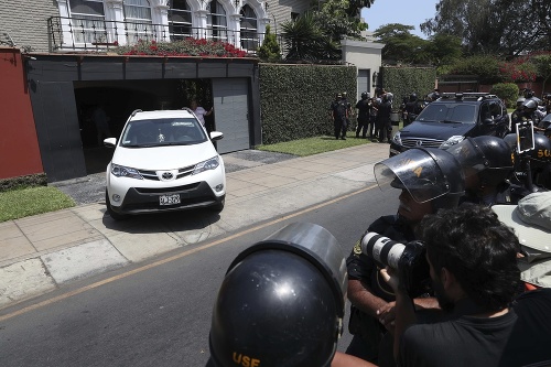 Policajti a novinári sledujú auto, ktoré odváža exprezidenta Peru Pedra Pabla Kuczynského z jeho domu . Sudca v Peru mu nariadil desaťdňovú väzbu v rámci vyšetrovania prania špinavých peňazí.
