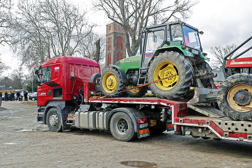 Niektoré traktory naložili na kamióny.