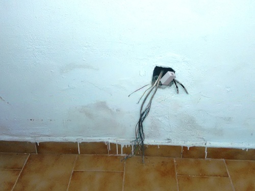 Steny izby boli špinavé a trčali z nich zväzky káblov.