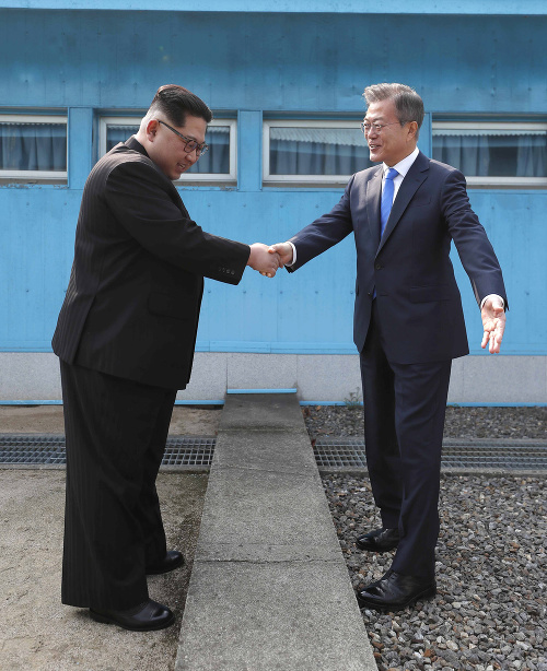 Severokórejský vodca Kim Čong-un (vľavo) a juhokórejský prezident Mun Če-in si podávajú ruky v dedine Pchanmundžom ležiacej v demilitarizovanej zóne.