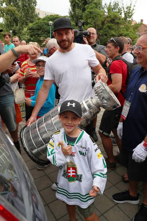 Michal Kempný s trofejou a malým fanúšikom zo Skalice, kde začal hokejovo rásť. 