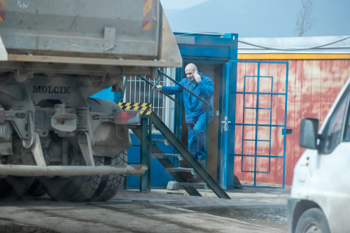 Trenčín, 27.3.2018, 11.28 hod. - Umelec s mobilom pri uchu kontroluje korbu nákladného auta.