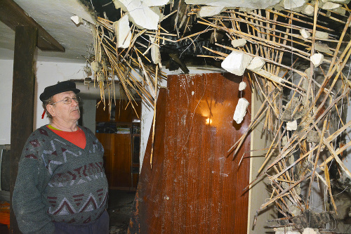 Jozef (72) ukazuje strop, ktorý mu zničil požiar.
