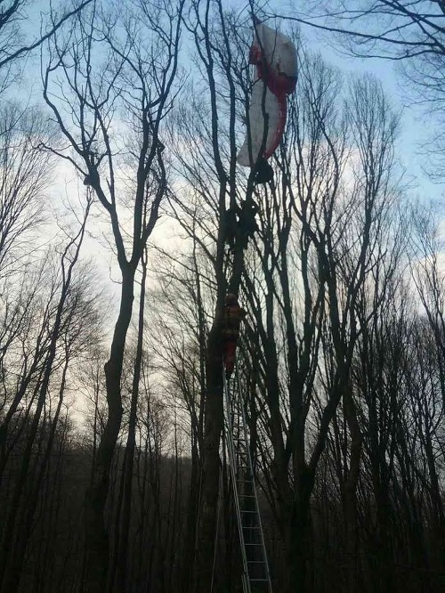 Paraglajdista visel na strome. Dole mu pomohli hasiči.