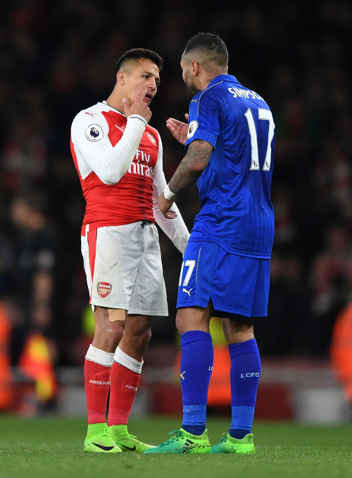 Útočník Arsenalu Alexis Sánchez (vľavo) ukazuje súperovi svoje zranenie.