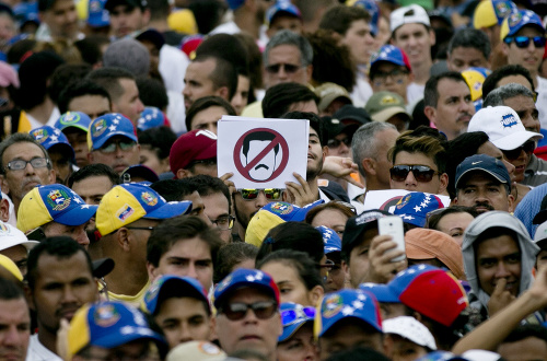 Ľudia protestujú proti venezuelskému prezidentovi Nicolásovi Madurovi počas protestného zhromaždenia v Caracase.