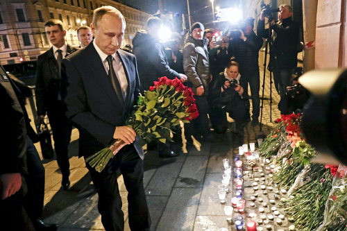 Ruský prezident Putin si obete uctil kyticou ruží. 