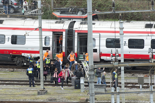 Záchranári stoja vedľa vykoľajeného vlaku na železničnej stanici vo švajčiarskom meste Luzern. 