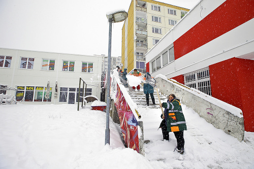 Aktivační pracovníci sa pri odhŕňaní snehu zo schodov poriadne zapotili.