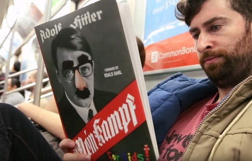 Komik číta v metre knihu s falošnou obálkou: Mein Kampf. Pre deti