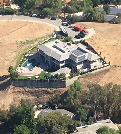 Letecký pohľad na vilu Chrisa Browna, vidieť pred ňou policajné autá.