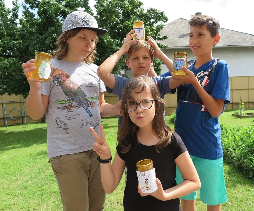 Malí školáci sa pýšia medom s vlastnoručne vyrobenou etiketou.