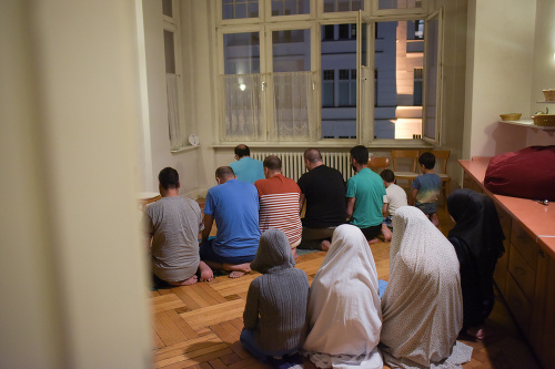 Migranti v bývalom berlínskom hoteli, ktorý teraz slúži ako ubytovňa pre utečencov, sa modlia po večeri.