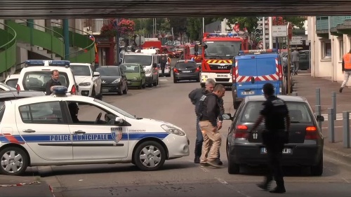Na snímke policajti sa rozprávajú s vodičom auta po uzatvorení cestnej komunikácie počas rukojemníckej drámy v kostole vo francúzskom meste Saint-Etienne-du-Rouvray.