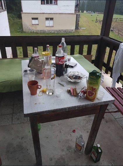 Na stole a pod ním sa váľali fľaše s alkoholom.