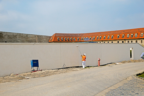 Betónový múr: Záhradu zatieni obrovský betónový múr.