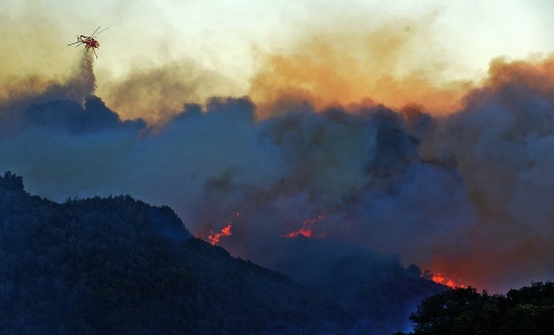 Hasičský vrtuľník hasí lesný požiar v lesoch neďaleko Santa Barbary v americkej Kalifornii.