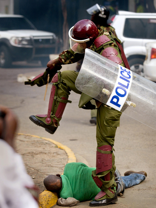 Z desivej snímky máme pocit, akoby sa policajt chystal Afričanovi dupnúť po hlave.