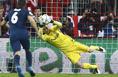 Na snímke vpravo brankár Atletica Madrid Jan Oblak chytá penaltu hráča Bayernu Thomasa Müllera.