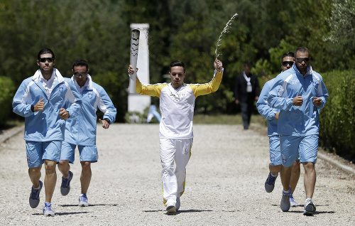 Grécky gymnasta Eleftherios Petrounias beží s olympijskou pochodňou počas zapálenia olymijského ohňa v starobylej Olympii.