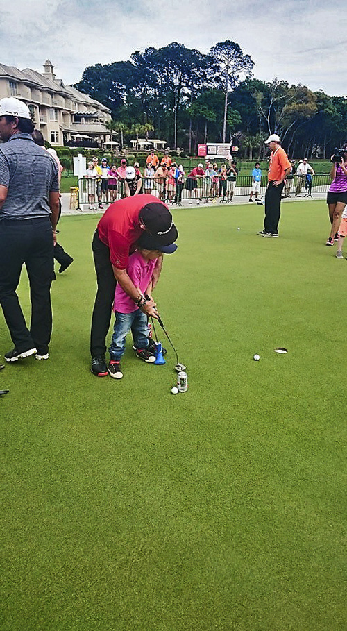 Rory Sabbatini chlapca učí hrať golf.