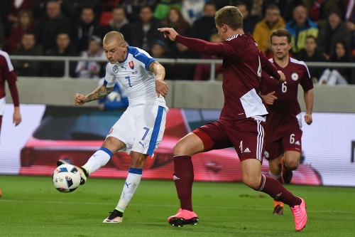  Vladimír Weiss (vľavo) a hráč Lotyšska Kaspars Dubra v súboji o loptu.