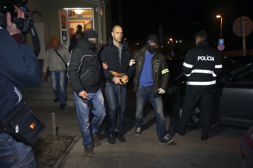 Dušana odvádzajú policajti z jeho bytu, po tom, čo uňho zaistili dôkazy.