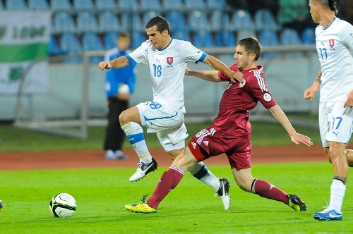 Slovák Viktor Pečovský (vľavo) v súboji o loptu s Lotyšom Aleksandrsom Fertovsom. 