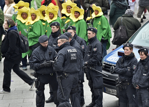 Policajti hliadkujú pred hlavnou železničnou stanicou účastníka počas začiatku pouličného karnevalu v Kolíne nad Rýnom.