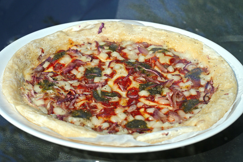 Pizza: Klasická mrazená pizza s mozzarellou, pestom a červenou cibuľou sa má podľa návodu ohrievať 14 minút v rúre vyhriatej na 230 stupňov. Nám sa na povrchu jemne pripiekla, ale cesto nebolo chrumkavé, ale len roztečené.