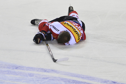 Otrasený Švajčiar Jérémie Kamerzin ostáva ležať na ľade po zrážke so Slovákom Andrejom Šťastným (nie je na snímke).
