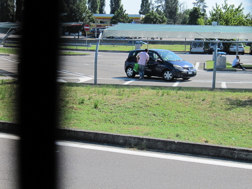 Podvodník uteká ku komplicovi, ktorý sedí v naštartovanom aute, a uháňajú preč.