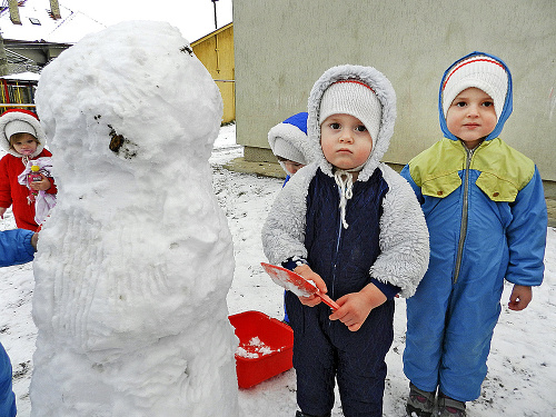 Filipko Géci (vľavo, 2) a Kristínka Pálešová (3) sa tešia, že môžu na dvore v detských jasliach šantiť pri snehuliakovi.