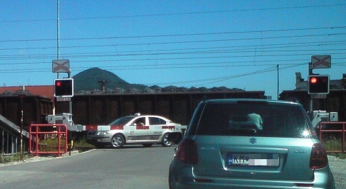 Prejazd nákladného vlaku si taxikár odsedel s rukou vyloženou v stiahnutom okne.