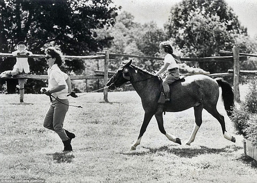 1963:Jackie na snímke s dcérkou Caroline počas hodiny jazdenia na jej koníkovi Makarónovi. 