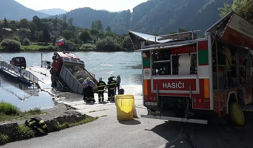 Žilinskí hasiči zasahujú pri kompe, z ktorej sa ťažký nákladiak zošmykol z kompy do rieky.